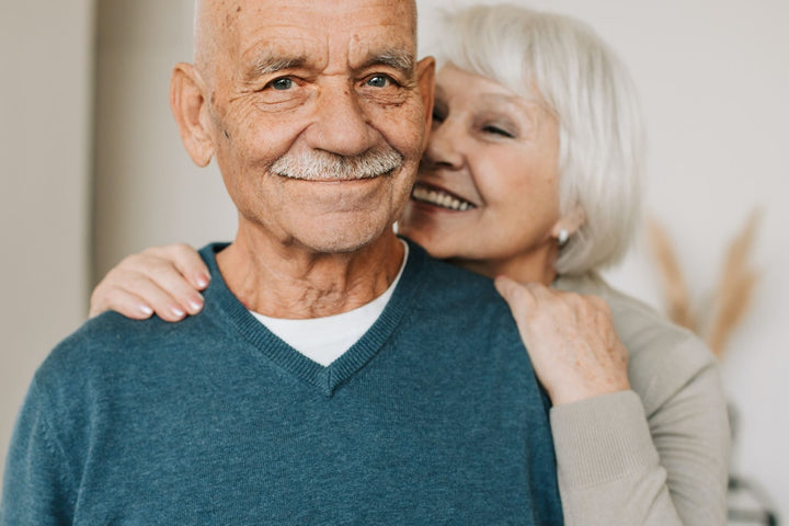An older man and woman embracing and smiling