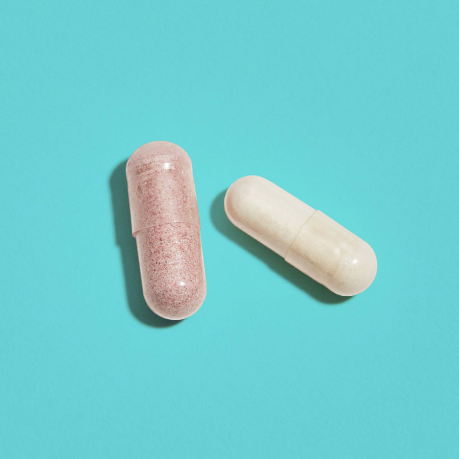 One purple tinted capsule next to a white capsule