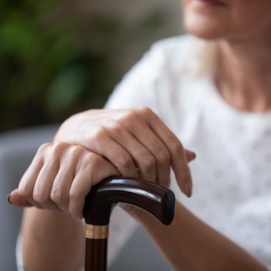 Woman's hands comfortably holding the handle of a cane