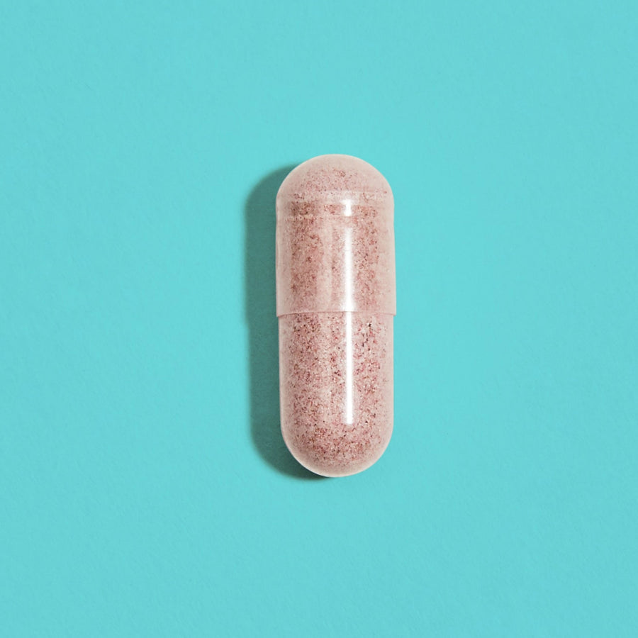 Capsule filled with pink UTI supplement powder
